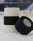 Two rolls of hockey tape on an ice rink with a blurred background