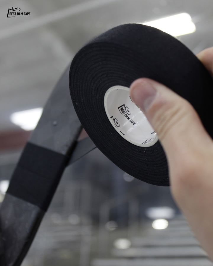 Player holding a roll of Best Dam black cloth hockey stick tape
