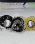 Three rolls of 'Best Dam Tape' tape on a snowy surface with a blurred background