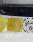 Two rolls of yellow tape with a label on a snowy surface, likely an ice rink.
