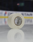 Roll of white tape on a reflective surface with blurred background