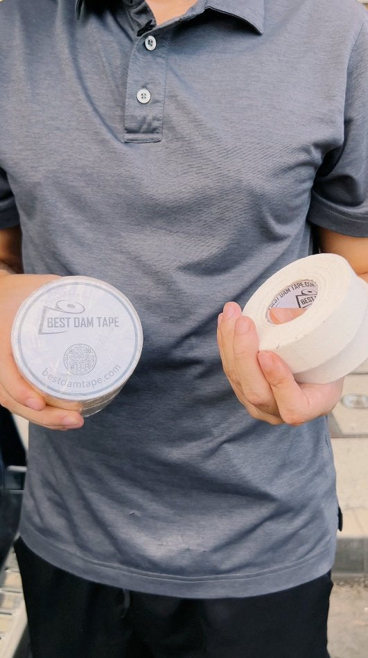 Equipment manager holding a roll of Best Dam clear and a roll of white cloth tape