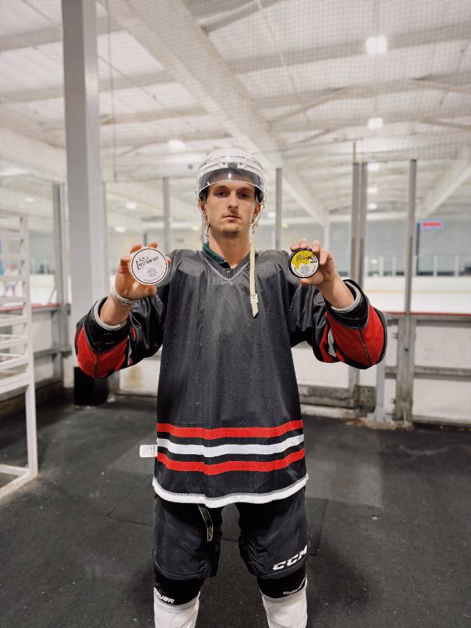 Player in a practice jersey holding up two rolls of Best Dam Tape