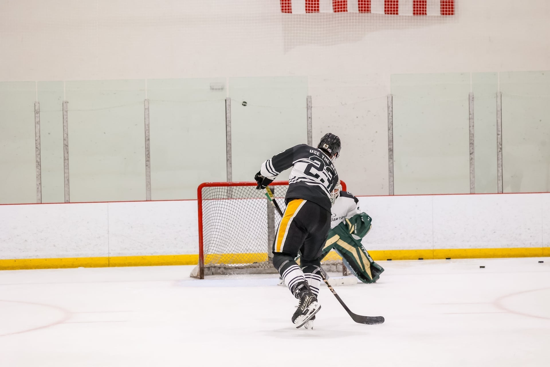 man playing hockey approaching goal
