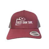 A maroon and grey snapback hat with the text 'BEST DAM TAPE' embroidered on the front.