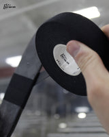 Player holding a roll of Best Dam black cloth hockey stick tape