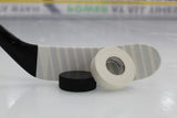 Hockey stick, puck, and Best Dam white cloth tape on white surface