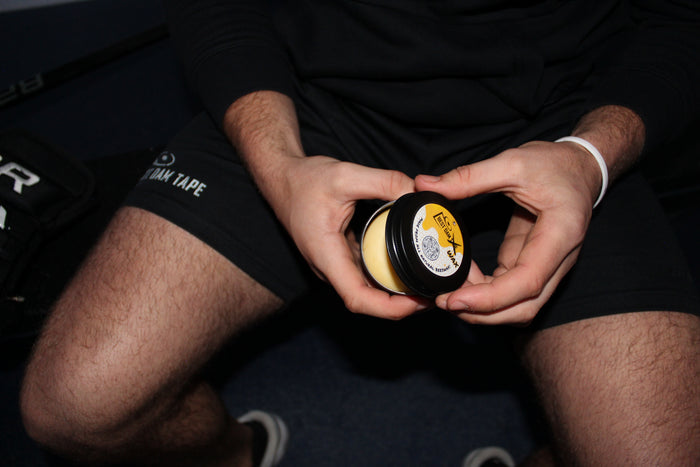 Best Dam Wax beeswax hockey wax tin with logo on dark surface