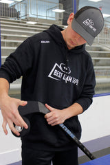 Hockey player in Best Dam Tape hoodie holding a stick on the ice