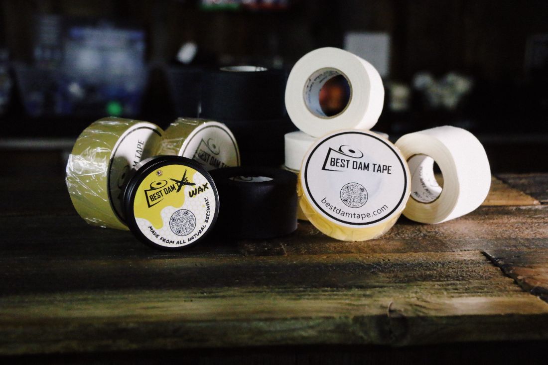 Best Dam clear, cloth, double wide and wax rolls grouped on a wood bench