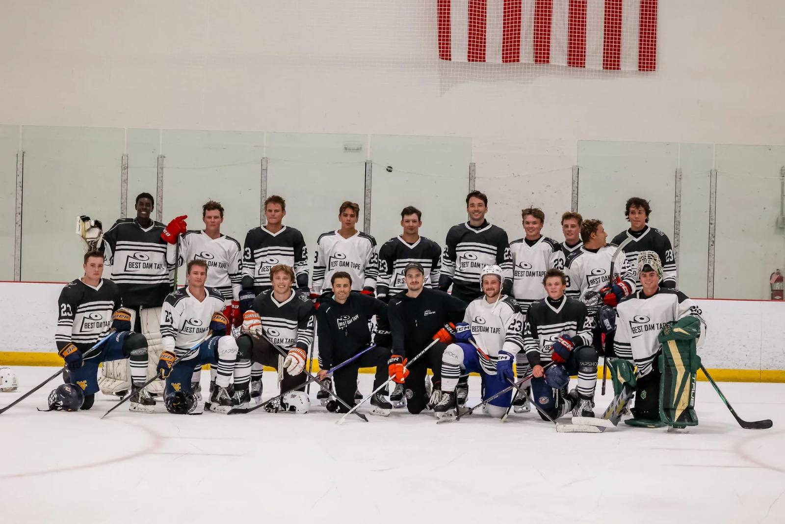 Team in Best Dam Tape jerseys kneeling on the ice