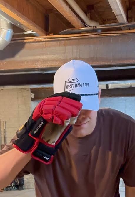 Player in a Best Dam Tape cap and hockey glove