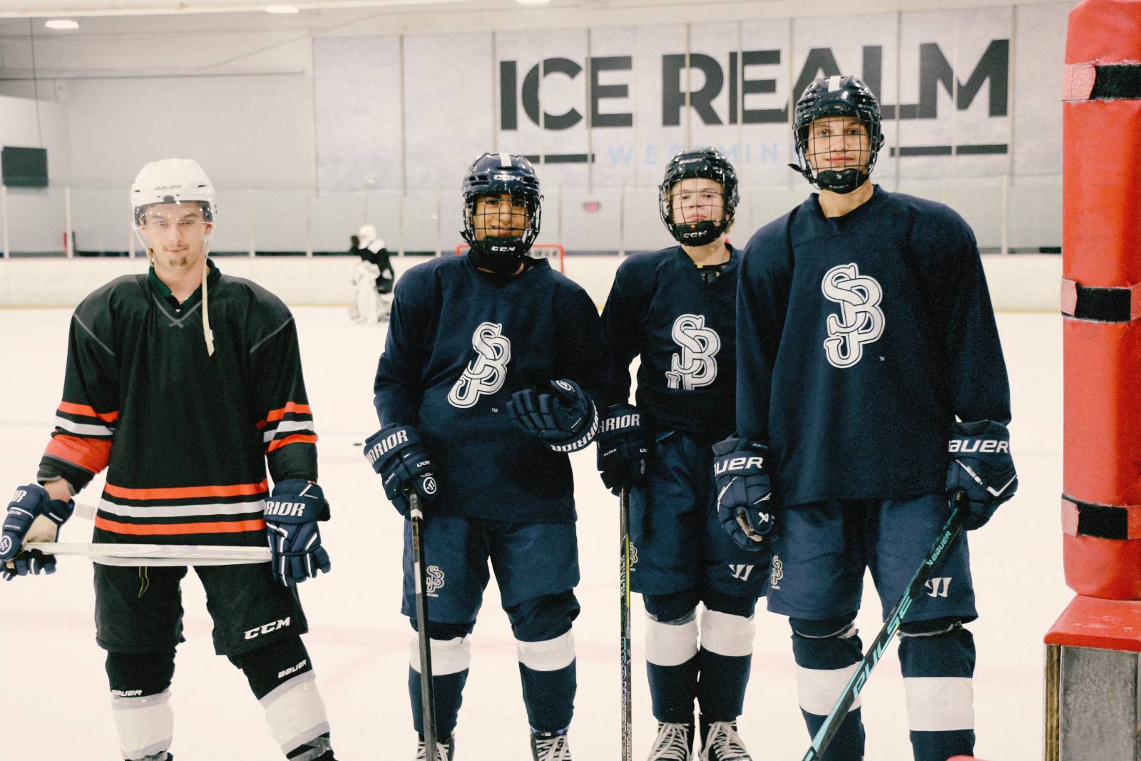 Players in practice jerseys lined up on the ice at Ice Realm